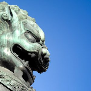 Bronze lion from the Forbidden City against a blue sky